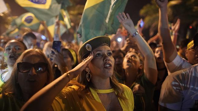 A supporter of Jair Bolsonaro salutes during a celebration in front of his residence after he was declared the winner of the election. Picture: AP.