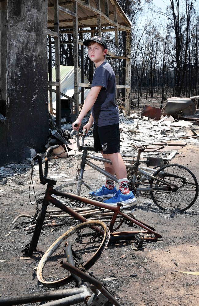 Alex Windsor, 11, with his burnt bike. Picture: Liam Kidston