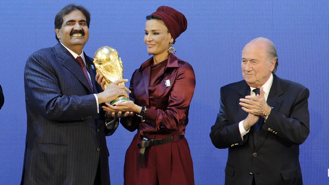 Emir of the State of Qatar Sheikh Hamad bin Khalifa Al-Thani (R) and his wife Sheikha Moza bint Nasser Al-Missned (C) receive the World Cup trophy from FIFA President Joseph Blatter in 2010. Photo: Sebastien Derungs/AFP.