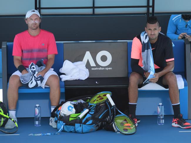 Bloody hot, mate: Nick Kyrgios (right) and fellow Australian Matt Reid take a break from the intense heat during their doubles match on Day 4. Picture: AAP