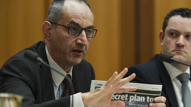 Home Affairs Department Secretary Mike Pezzullo holds up a copy of the Sunday Telegraph newspaper during a hearing of parliamentary intelligence and security committee at Parliament House in Canberra. Picture: Lukas Coch/AAP