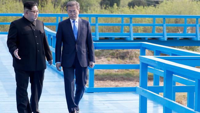 Kim Jong Un and Moon Jae-in walk on a bridge after a tree-planting ceremony at the truce village of Panmunjom. Picture: AFP