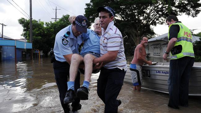 Police evacuate an 83-year-old resident who needed urgent medical attention as flood waters cover Brisbane on January 12, 2011.