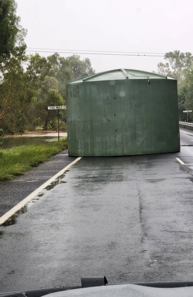 Flash flooding at One Mile Creek near Cardwell has washed a polytank up on to the road. Photographer Kerry Brady took the photo Monday morning after being blocked on the road by the obstruction.