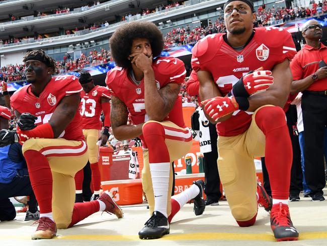 (FILES) In this file photo taken on October 02, 2016 (L-R) Eli Harold #58, Colin Kaepernick #7 and Eric Reid #35 of the San Francisco 49ers kneel on the sideline during the anthem prior to the game against the Dallas Cowboys at Levi's Stadium in Santa Clara, California. - Former San Francisco 49ers quarterback Colin Kaepernick has been chosen as the face of a new Nike advertising campaign to mark the 30th anniversary of the company's iconic "Just Do It" slogan, it was confirmed on September 4, 2018. Kaepernick -- who triggered a political firestorm after kneeling during the US national anthem in 2016 to protest racial injustice -- has not played in the NFL since early last year.The 30-year-old is suing the NFL, claiming he has been frozen out of the league by team owners because of his activism. (Photo by Thearon W. Henderson / GETTY IMAGES NORTH AMERICA / AFP)