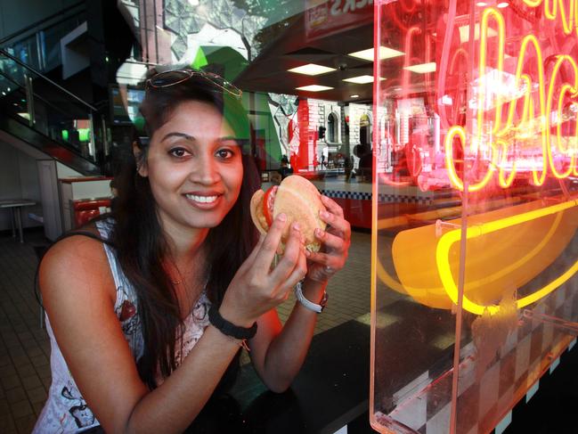 Hungry Jack stores have included the kilojoule information of their food next to the price on the menu board. Alisha Naik eats a chicken burger at the Swanston street store.