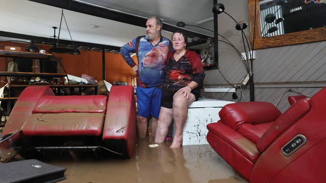 Clitheroe Street residents David and Tracy Ebert look for items to salvage from the lounge room, after flood water inundated their Cardwell home overnight. Picture: Brendan Radke