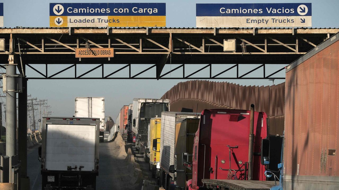 Trucks wait on a queue to cross to the US next to the border wall at the Otay commercial crossing port in Tijuana, Baja California state, Mexico. Picture: Guillermo Arias/AFP