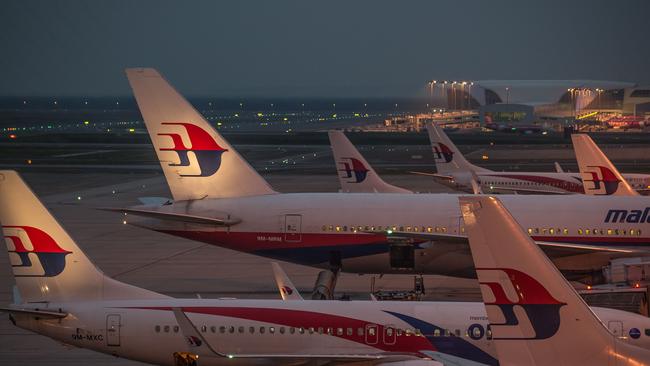 Ground staff prepare Malaysia Airlines planes for departure at Kuala Lumpur International Airport in Sepang on July 30, 2014. The remains of Flight MH17 victims will be handed over to the Netherlands, while Malaysia will receive the doomed plane's black boxes after Kuala Lumpur struck a breakthrough deal with Ukrainian separatists on July 22. AFP PHOTO / MOHD RASFAN