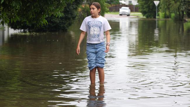 Annabella Giorgas, 11, walks along her street in the Hermit Park suburb of Townsville on Monday. The low-lying suburbs barely avoided disastrous water levels. Picture: Adam Head /NewsWire