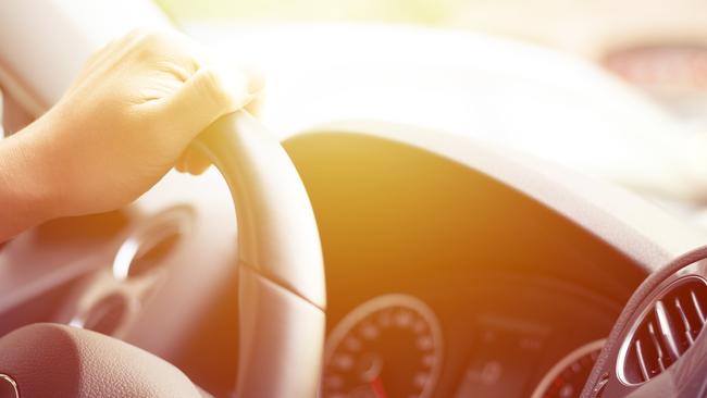 Close-up of Man Driving a Car Hand on Steering Wheel.