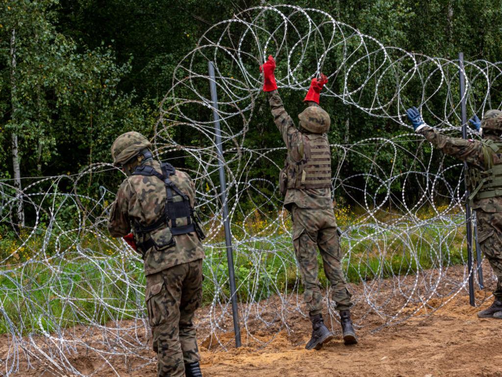 Polish Army Soldiers build a fence with concertina wire at the Belarusian border in order to stop immigrants from entering the country.