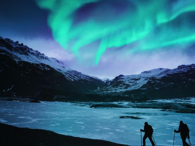 Hikers under the northern lights in Iceland.