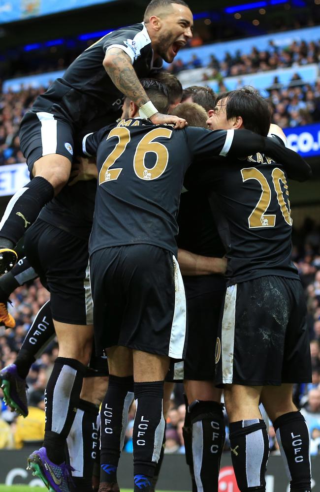 Leicester City's Robert Huth, hidden, celebrates with teammates.