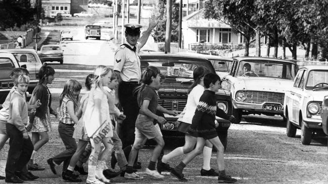 A police officer helps children cross the road in 1972.