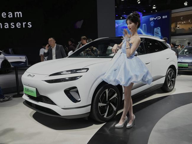 A model poses near the Sea Lion 06 DM-i model from BYD at the Shanghai auto show on Wednesday, April 23, 2025. (AP Photo/Ng Han Guan)