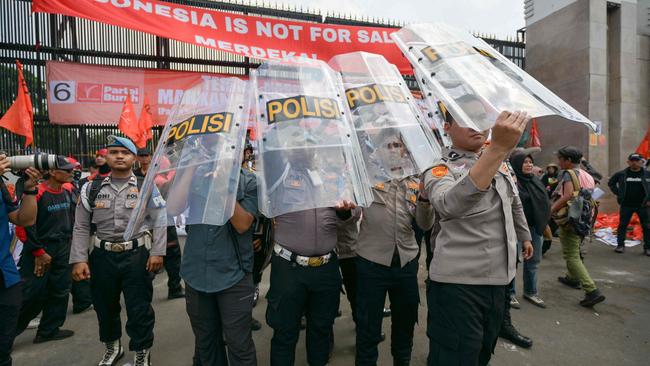 Police use their shields to protect themselves during a protest outside parliament in Jakarta. Picture: AFP