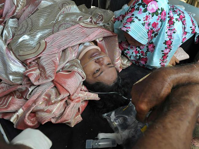 An earthquake survivor is accompanied by her family at a district hospital in Pidie Jaya, Aceh province. Picture: AFP