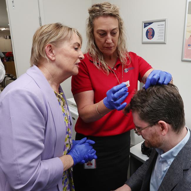 Ros Bates Shadow Minister for Health and Ambulance Services medically assisting journalist Andrew Messenger who split his head open on his way to a media conference, The Family Practice Emu Park. Picture: Liam Kidston.