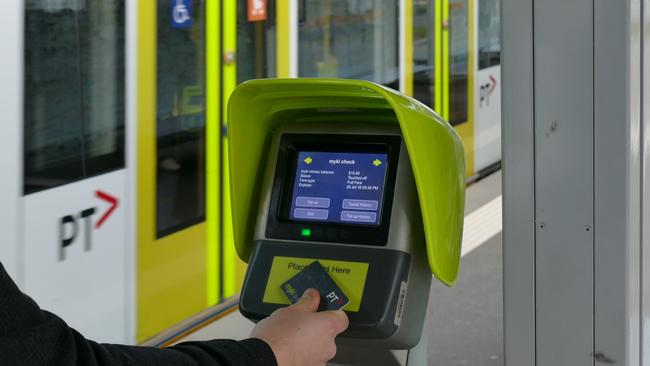 A passenger uses a myki Quick Top Up machine.