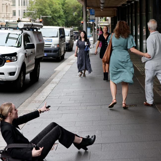 News Corp journalist Eliza Barr on the ground, outside Sydney Downing Centre, after the alleged assault by Cignetti (grey suit) on Wednesday.