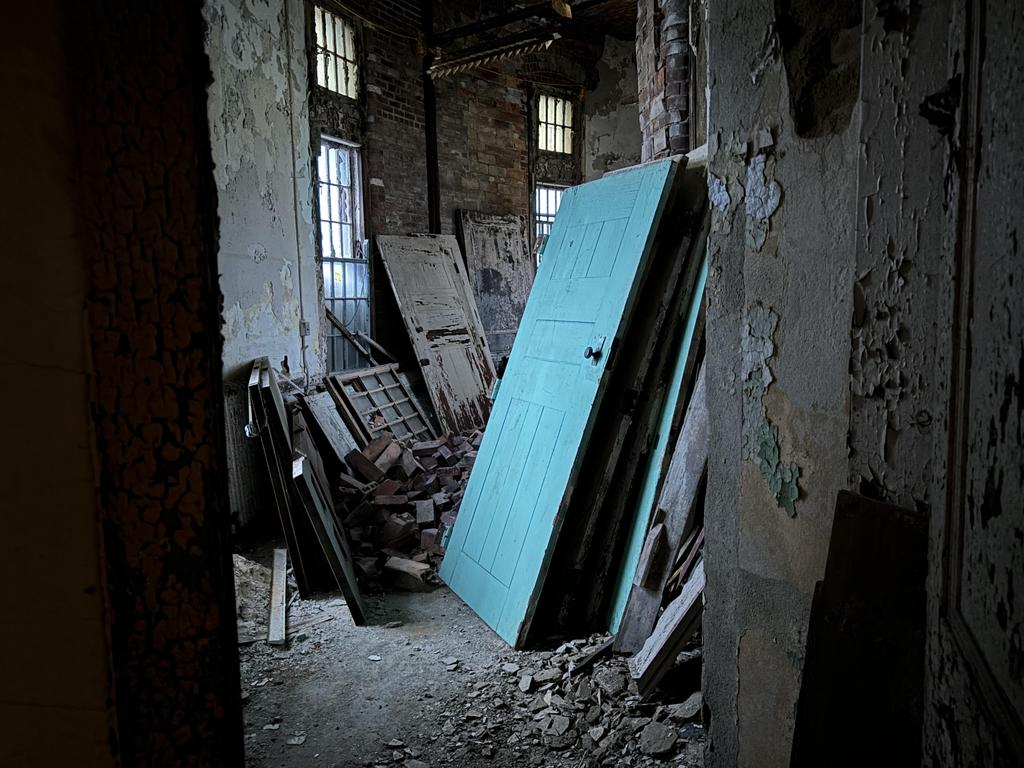 An old door in a corner of the former asylum. Picture: Benedict Brook/news.com.au.