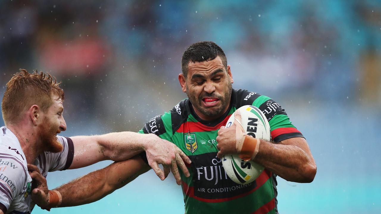 Rabbitoh's Greg Inglis fends off Manly’s Brad Parker.