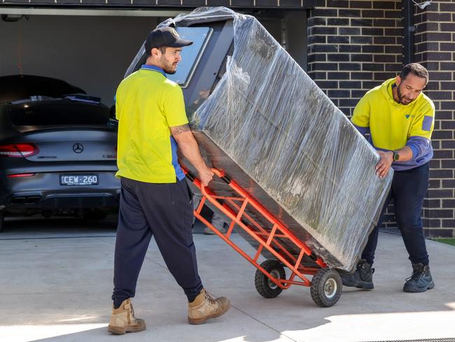 A fridge is removed from the home following a police raid of the property. Picture: Ian Currie