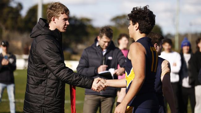 AFL player Tom J. Lynch of the Tigers (L) hands a medal to Cooper Trembath of Whitefriars College. Picture: Daniel Pockett/AFL Photos/via Getty Images