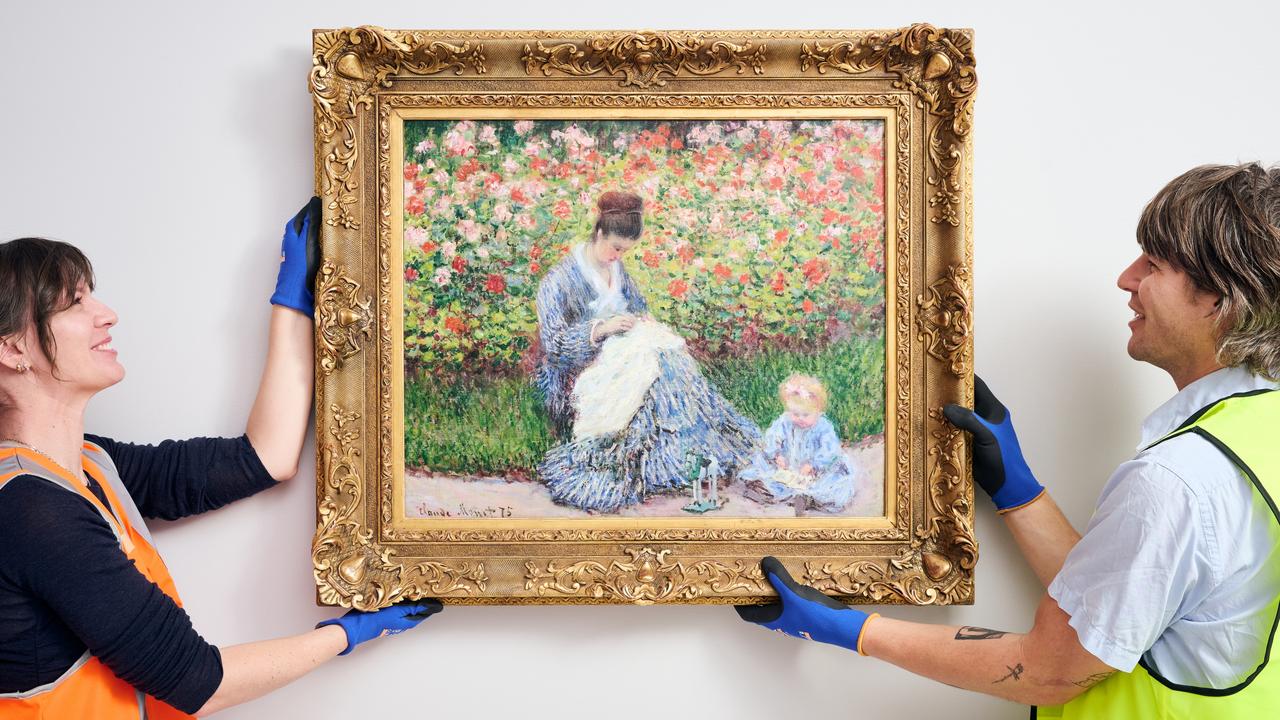 NGV art handlers Phoebe and Tom installing Claude Monet’s Camille Monet and child in the artist’s garden in Argenteuil 1876 last week. Photo: Eugene Hyland