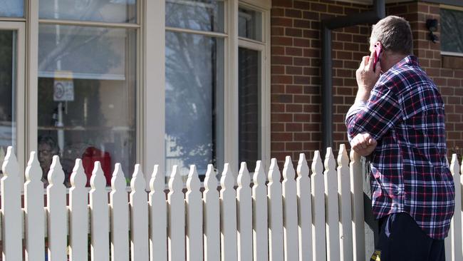 Colin Wilkins speaks to his mum on the phone at her room window. Picture: Sarah Matray