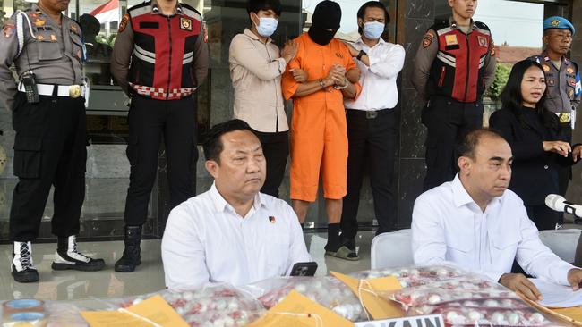 Lamar Aaron Ahchee with Bali police during a press conference on Monday. Picture: Lukman S. Bintoro