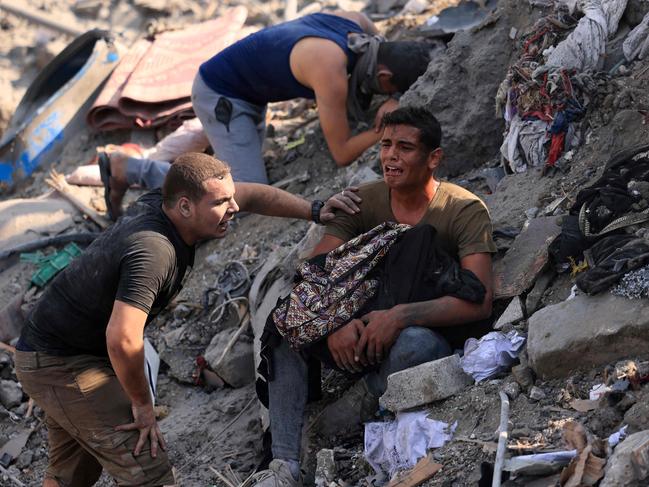 A man reacts as he holds the remains of his mother wrapped in a blanket amid the rubble of building destroyed in an Israeli strike on the Bureij refugee camp in the central Gaza Strip. Picture: AFP