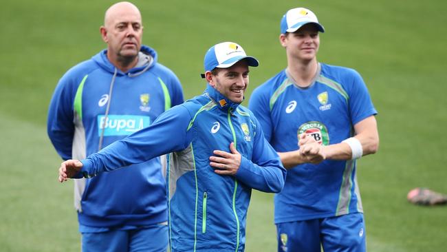 Darren Lehmann watches on as Chadd Sayers and Steve Smith warm up at training.