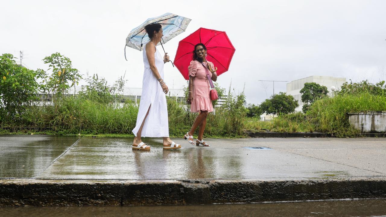 Wet weather remains stubbornly persistent across Far North Queensland. Renee Moseley and Meena Rastoka have a chat and a laugh as the walk along a soggy Hartley St. Picture: Brendan Radke