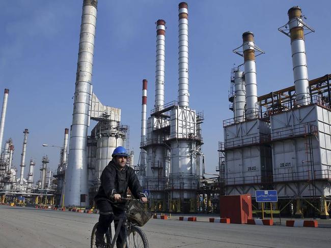 An Iranian oil worker rides his bicycle through the Tehran oil refinery, south of the capital Tehran, Iran. Iran’s determination to raise oil output when sanctions are lifted means short-term efforts to reduce the current supply glut are unlikely to succeed. PHOTO: VAHID SALEMI/ASSOCIATED PRESS