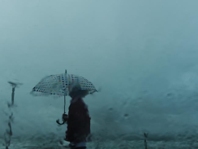 Continued rain on Sydney's Northern Beaches didn't stop people from getting out and about on Thursday. Queenscliff Beach/ Umbrella/ rain/ window/ grey/