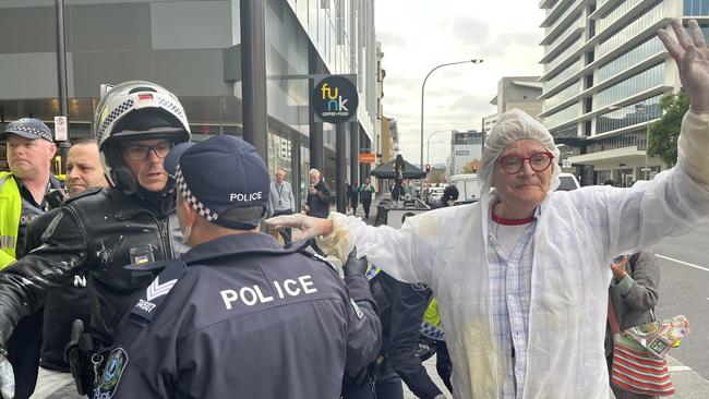 Police with an Extinction Rebellion protester outside the Santos building on Thursday morning. Picture: Supplied