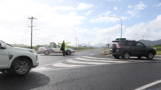 A police officer blocks the Captain Cook Highway at the Yorkeys Knob roundabout earlier today. PICTURE: STEWART McLEAN