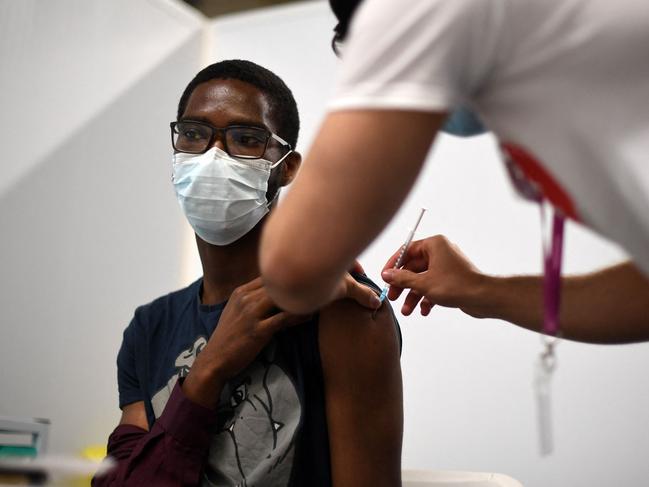 Members of the public receive a dose of a Covid-19 Pfizer vaccine inside a temporary vaccination centre in London. Picture: AFP