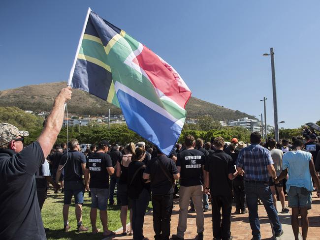 A protester waves a flag during a demonstration by South African farmers & farm workers  at the Green Point stadium to protest against farmer murders in the country, on October 30, 2017, in Cape Town. Thousands of white farmers blocked roads in South Africa on October 30 to protest against what they say is an explosion of violence against their communities in rural areas. Large demonstrations under the "Black Monday" banner were held in Cape Town, Johannesburg and the capital Pretoria. Marchers dressed in black to commemorate the victims of hundreds of deadly "farm attacks" in recent years. / AFP PHOTO / DAVID HARRISON