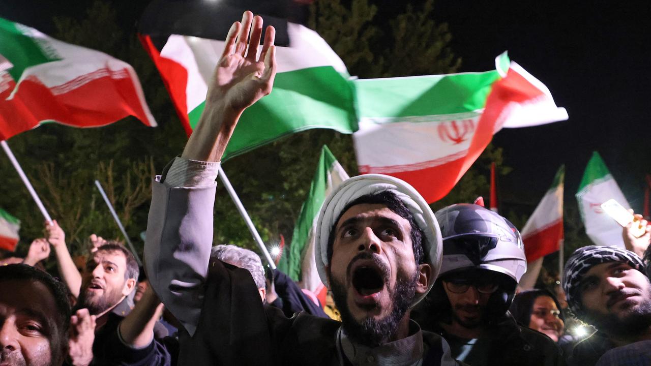 Demonstrators wave Iran’s flag and Palestinian flags as they gather in front of the British Embassy in Tehran. Picture: AFP