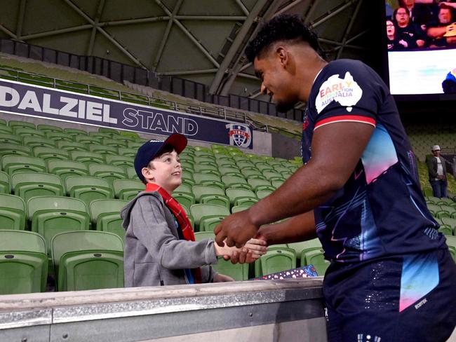 A young Rebels supporter shakes hands with Rebels' Isaac Kailea. Picture: AFP