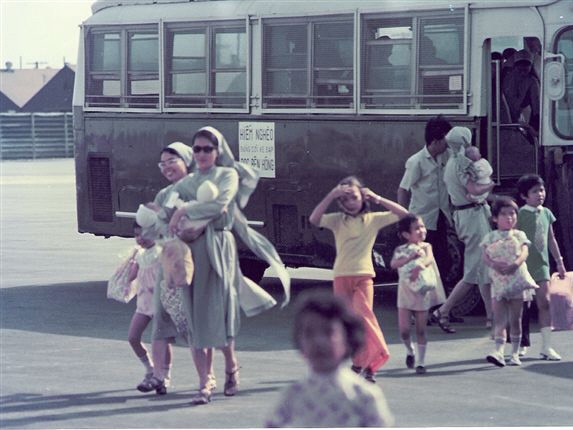 Children leave the bus on tarmac at Saigon Airport during Operation Baby Lift in Vietnam 1975