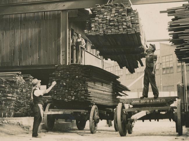 Workers load wooden planks during the construction of a ride.