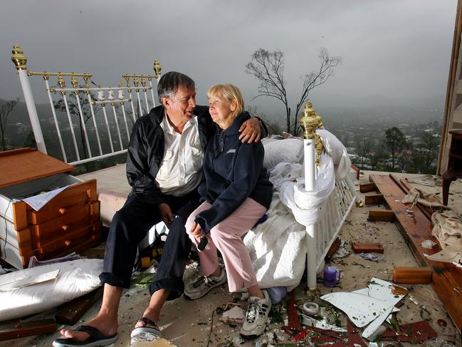 Clean up after vicious storms at The Gap: Vowing to rebuild, Graham and Lynette Bigby sit in the demolished bedroom of their once great Kimruska Place home