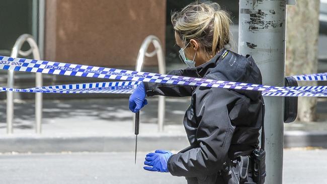 A police office holds up a knife at the scene. Picture: Tim Carrafa