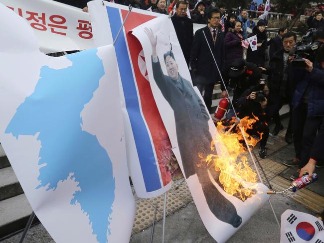 South Korean protesters burn a portrait of North Korean leader Kim Jong Un during a rally against a visit of North Korean Hyon Song Wol, head of North Korea's art troupe, in front of Seoul Railway Station in Seoul, South Korea, Monday, Jan. 22, 2018. "Executed" North Korean pop diva takes Olympic spotlight, but Hyon was met at Seoul railway station by about 150 to 200 activists. The demonstrators later burned Kim's photo, a North Korean flag and a "unification flag" the rival Koreas plan to carry during the opening ceremony. (AP Photo/Ahn Young-joon)