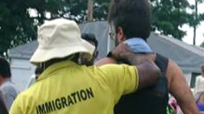 An asylum-seeker, right, is apparently forcibly removed from the Manus Island regional refugee processing centre today. Picture: AFP