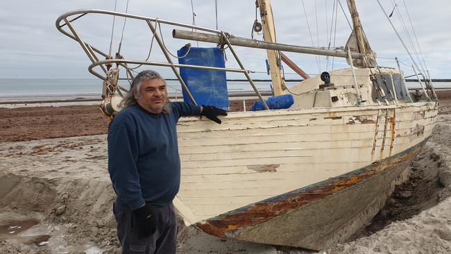 Novice sailor Claude Evans with his stranded yacht at North Haven. Picture: Colin James